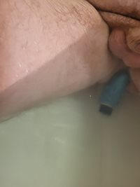 Soaking in the tub with a toy thinking about a special cock